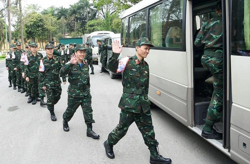 Les militaires participant à la mission humanitaire au Myanmar montent dans le bus pour se diriger vers l'aéroport de Noi Bai. Photo : QDND.