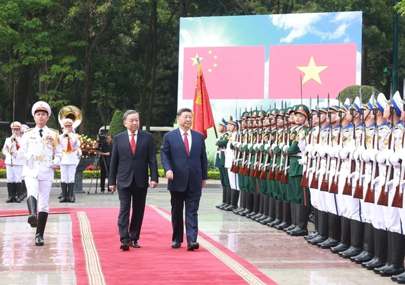 Le secrétaire général du PCV, Tô Lâm (à gauche), et le secrétaire général du PCC et président chinois, Xi Jinping, passent en revue la garde d'honneur de l'Armée populaire du Vietnam. Photo : VNA.
