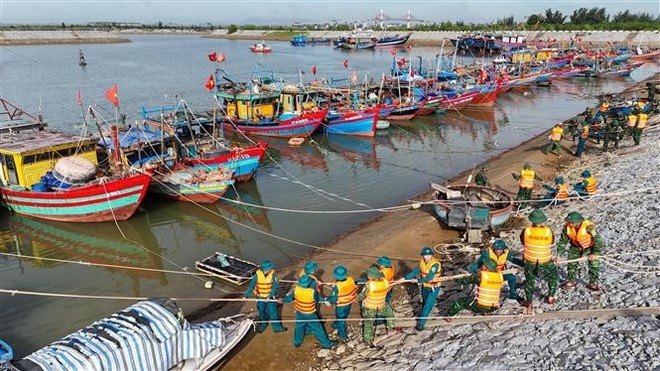 Des forces militaires soutiennent l'ancrage au refuge anti-tempête à Cua Hoi (commune de Dan Hai, province de Ha Tinh). Photo : VNA Des forces militaires soutiennent l'ancrage au refuge anti-tempête à Cua Hoi (commune de Dan Hai, province de Ha Tinh). Photo : VNA