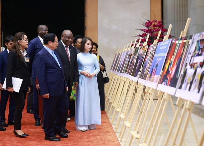Le Premier ministre Pham Minh Chinh et le président sud-africain Matamela Cyril Ramaphosa visitent une exposition photographique sur la coopération entre les deux pays, produite par l'Agence vietnamienne d'information. Photo : VNA Le Premier ministre Pham Minh Chinh et le président sud-africain Matamela Cyril Ramaphosa visitent une exposition photographique sur la coopération entre les deux pays, produite par l'Agence vietnamienne d'information. Photo : VNA