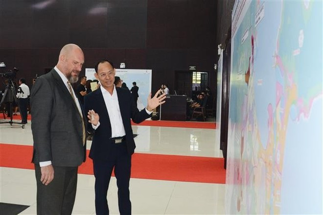 Un représentant d'une entreprise vietnamienne discute avec un partenaire étranger de la zone de libre commerce de Da Nang lors de la cérémonie. Photo : VNA. Un représentant d'une entreprise vietnamienne discute avec un partenaire étranger de la zone de libre commerce de Da Nang lors de la cérémonie. Photo : VNA.