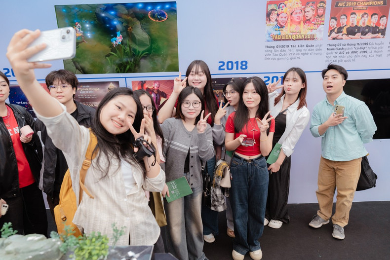 La Foire d’automne 2025 séduit également de nombreux jeunes visiteurs, notamment grâce aux stands des éditeurs de jeux vidéo et aux ateliers de création artisanale. Trinh Duc Hien (1er à droite), venu avec ses amis dès neuf heures du matin, a visité de nombreux stands et a confié avoir particulièrement apprécié celui du Théâtre national de marionnettes du Vietnam, qui lui a permis de découvrir la culture traditionnelle. Photo : vnexpress.net