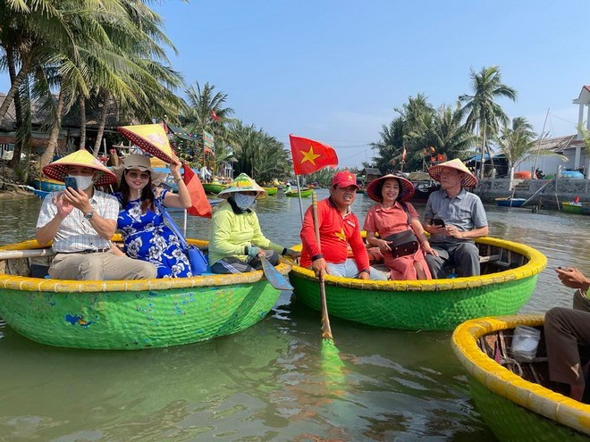 Des visiteurs profitent d’une balade en bateau rond en bambou au cœur de la forêt de cocotiers de Bay Mau, à Hoi An. Photo : VNA.