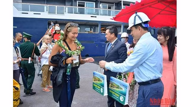 Des représentants du Service du tourisme de Quang Binh et du port Hon La accueillent et offrent des cadeaux aux touristes. Photo : NDEL. Des représentants du Service du tourisme de Quang Binh et du port Hon La accueillent et offrent des cadeaux aux touristes. Photo : NDEL.