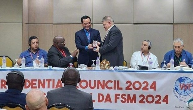 Le président de la Confédération générale du Travail du Vietnam, Nguyên Dinh Khang, a présenté un souvenir au comité d'administration de la Fédération syndicale mondiale. Photo : VNA.