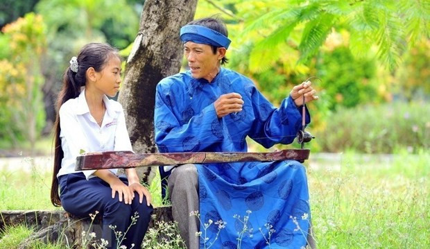 L'artiste Ly Van Toi enseigne le « don ca tai tu » à une fille. Photo : VNA.