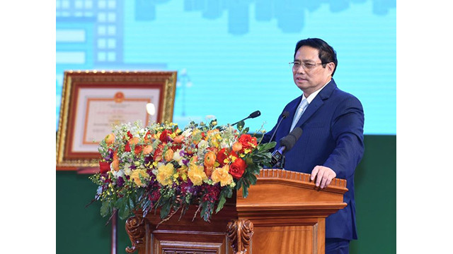Le Premier ministre Pham Minh Chinh regarde un modèle de voiture fabriqué par Ford Vietnam. Photo : NDEL.