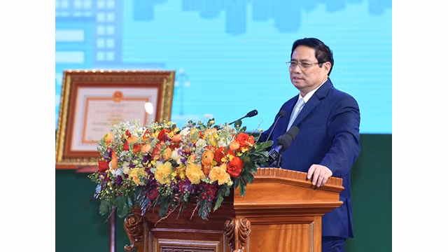 Le Premier ministre Pham Minh Chinh regarde un modèle de voiture fabriqué par Ford Vietnam. Photo : NDEL.