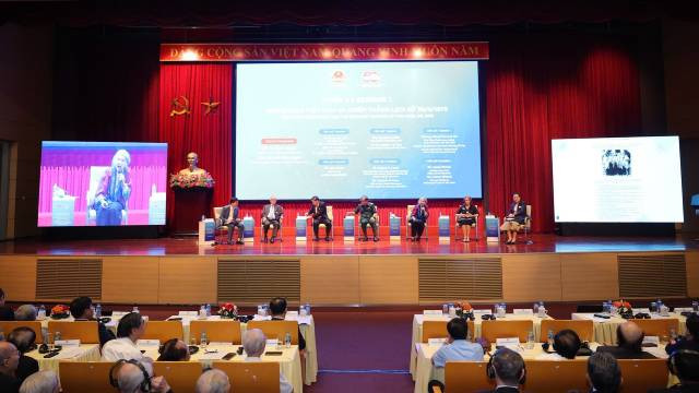 Les experts échangent lors du colloque scientifique international "50 ans de réunification nationale : Le rôle de la diplomatie dans la construction de la paix, hier et aujourd'hui". Photo : nhandan.vn
