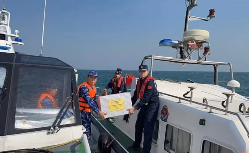 Les garde-côtes vietnamiens et chinois s'offrent les uns aux autres des cadeaux après la fin de leur patrouille conjointe. Photo : VNA.