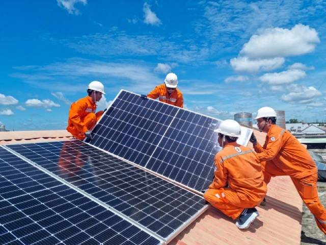 Les ouvriers de la Compagnie générale d'électricité de Hô Chi Minh-Ville installent un système solaire sur le toit. Photo : nhandan.vn