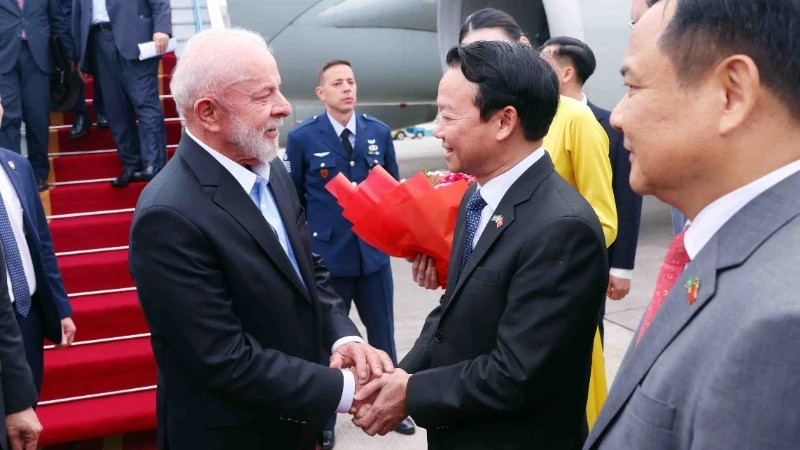  Le ministre de l'Agriculture et de l'Environnement, Dô Duc Duy, accueille le Président du Brésil, Luiz Inácio Lula da Silva, à l'aéroport international de Nôi Bài, à Hanoi. Photo: VNA