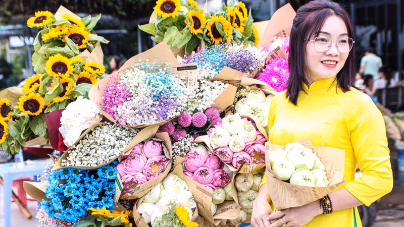 De nombreuses femmes portent l’ao dai (longue robe traditionnelle vietnamienne) pour prendre des photos afin de capturer l’arrivée de l’automne au milieu des fleurs colorées. Photo: daidoanket