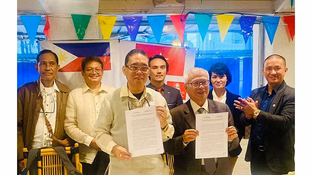 La signature du procès verbal de la réunion entre l'Association d’amitié Vietnam - Philippines et l’Association d’amitié Philippines - Vietnam. Photo : thoidai.com.vn