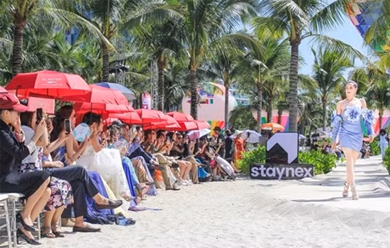 Un défilé de mode présenté par des candidates de Miss Grand International 2023 dans le site historique national spécial de la pagode Thây. Photo: Journal Phap Luât