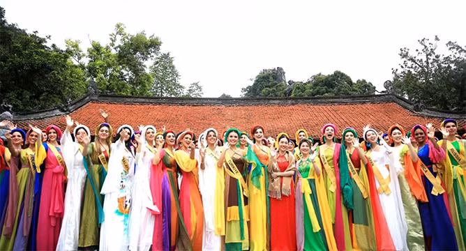 Les candidates de Miss Grand International 2023 portent la tunique traditionnelle vietnamienne à 4 pièces imprégnées de la culture vietnamienne conçues par la designer Thach Linh au site historique national spécial de la pagode Thây. Photo: thoidai.com.vn