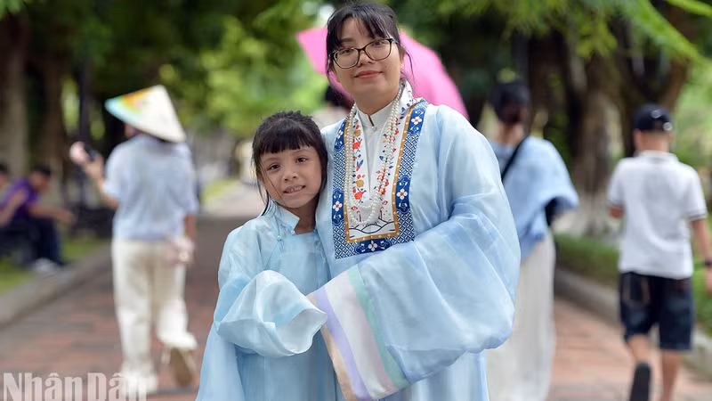 Mme Phuong et sa fille, Tuê Nhi, sont heureuses dans le « ao dài » à cinq pièces de même couleur. Photo : nhandan.vn