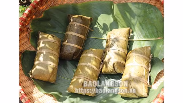 Les gens utiliseront des feuilles "dong" (Stachyphrynium placentarium ) pour envelopper le « banh chung », le gâteau doit être bien emballé, chacun fait d'environ 28 à 30 cm de long. Une fois bouilli, le gâteau est immergé dans l'eau, cuit pendant environ 9 heures, puis le sortir, une fois cuit, il a une très belle couleur bleu violet. Photo : baolangson.vn