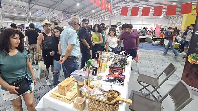 Lors de la foire, des centaines de consommateurs et d'entreprises chiliens sont venus se renseigner et échanger des informations dans la zone des stands de l'ASEAN et du Vietnam. Photo : baoquocte.vn