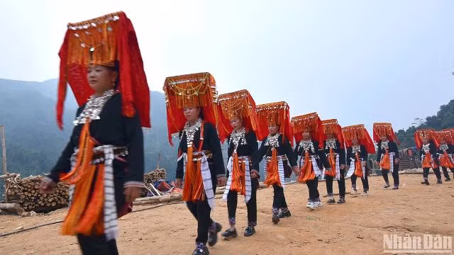 Des femmes portent leur costume traditionnel pendant la cérémonie. Photo : nhandan.vn