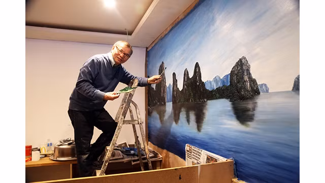 Le peintre Vu Kim Thanh et son œuvre sur la baie de Ha Long. Photo : Vu Kim Thanh.