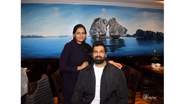 Les convives étrangers à côté de la peinture à l'huile de la baie de Ha Long au restaurant Viet Rest. Photo : Vu Kim Thanh.