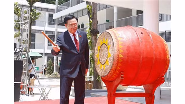 Le Président de l’Assemblée nationale, Vuong Dinh Hue, bat le tambour du lycée de Ky Son. Photo: VNA