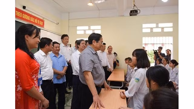 Le Premier ministre Pham Minh Chinh et des élèves de l’école primaire du bourg de Yen Lap. Photo : NDEL.