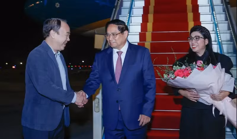 Le Premier ministre Pham Minh Chinh (au centre) et son épouse sont accueillis par le vice-président du bureau du gouvernement Nguyen Sy Hiep à l'aéroport international de Noi Bai. Photo : VNA.