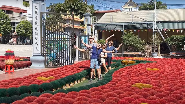 Les touristes étrangers sont fascinés par une carte du Vietnam créée avec des centaines de bouquets de bâtonnets d’encens colorés dans le village de Quang Phu Cau. Photo : Phuong Trang.