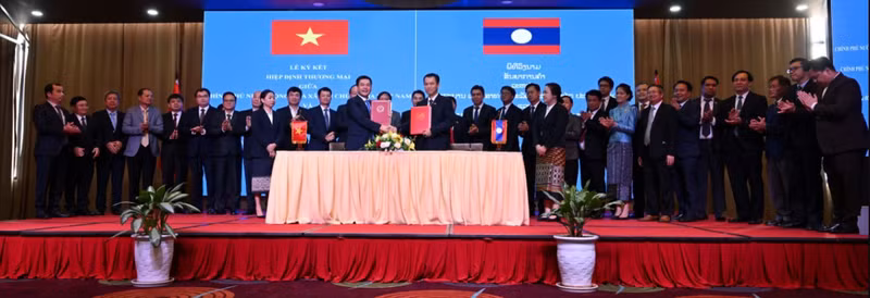 Le ministre Nguyen Hong Dien et son homologue laotienne signent le nouvel accord commercial Vietnam-Laos en avril 2024. Photo de : baocongthuong