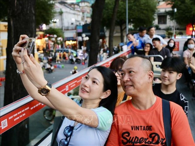 Les touristes découvrant Hô Chi Minh-Ville sur le pont d'un autobus à impériale. Photo : VNA.