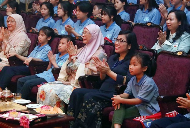 Mesdames Lê Thi Bich Trân (1er plan, deuxième à partir de la droite) et Dato’ Seri Dr. Wan Azizah binti Dr. Wan Ismail (1er plan, troisième) regardent des spectacles de marionnettes sur l’eau au Théâtre d’art contemporain du Vietnam à Hanoi le 20 juillet. Photo : VNA.