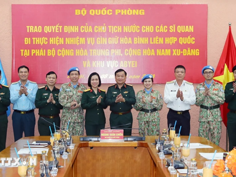 Lors de la cérémonie pour remettre à trois officiers les décisions du président de la République et du ministre de la Défense concernant leur participation à la Mission multidimensionnelle intégrée des Nations unies. Photo : VNA.