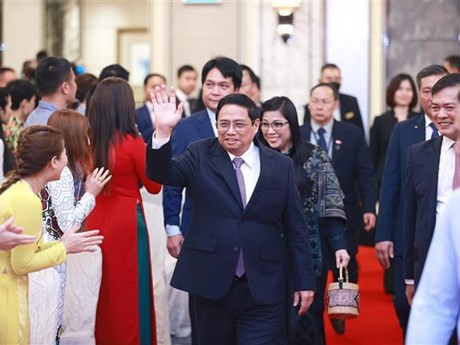 Le Premier ministre Pham Minh Chinh et son épouse lors de la rencontre avec communauté vietnamienne à Singapour, le 8 février 2023. Photo : VNA.