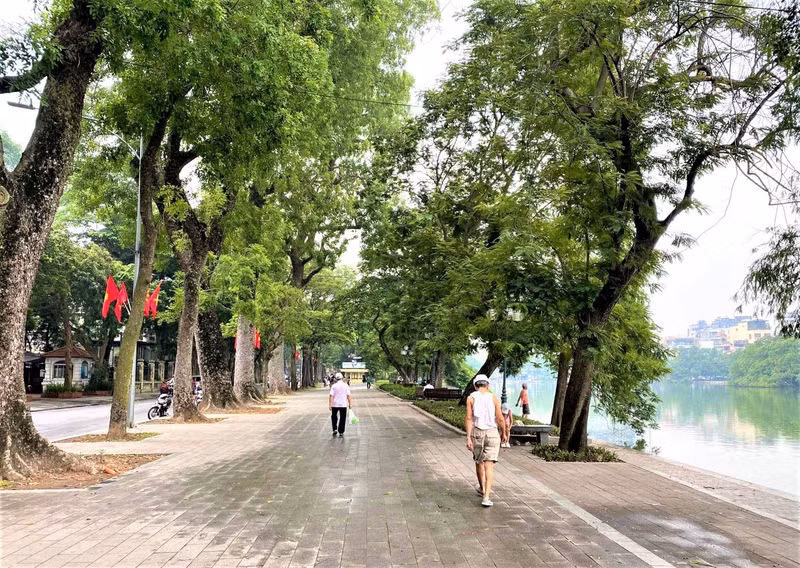 Les gens se promener au bord du lac Hoàn Kiêm. Photo : Thuy Linh.