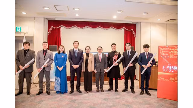 Le Comité d'organisation offre des cartes du Vietnam aux représentants des Associations lors de la cérémonie en réponse à la campagne « Fier du pays ». Photo : Comité d'organisation.