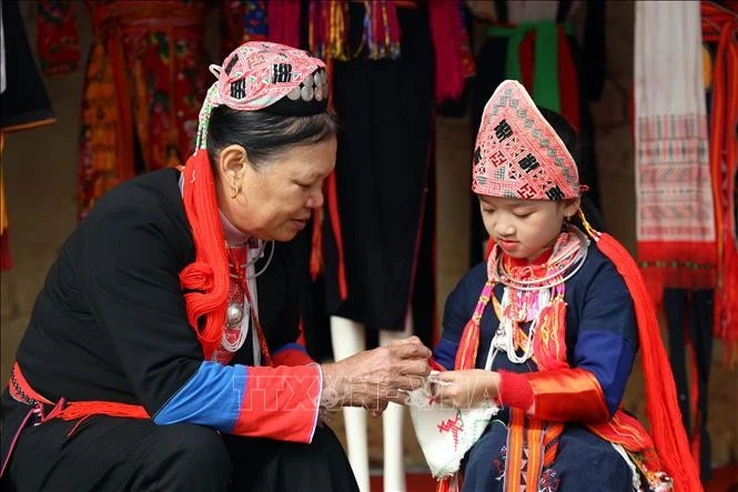 Les Dao cousent pour eux-mêmes et leur famille les plus beaux vêtements à porter pendant les vacances du Têt. Photo: thoi dai