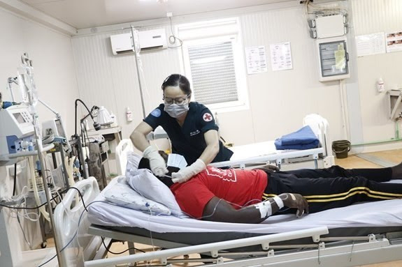 Une femme médecin militaire de l'hôpital de campagne n° 3 de niveau 2 au Soudan du Sud examine un patient. Photo : Département des Opérations de maintien de la paix.