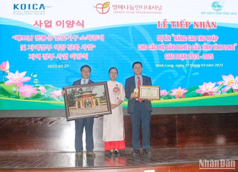 Lors de la cérémonie pour recevoir le projet « Amélioration des revenus des ménages pauvres de Vinh Long » pour la période 2023-2025. Photo: NDEL