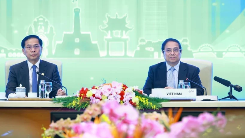 Le Premier ministre Pham Minh Chinh (à droite) préside la discussion plénière de haut niveau sur la « Transition verte durable et centrée sur l'humain ». (Photo : VNA)