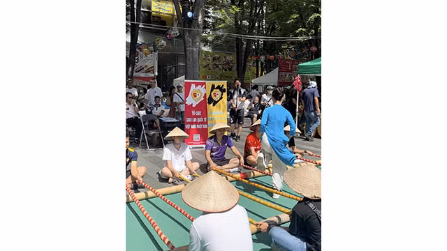 Les gens participent à la danse traditionnelle « sạp » (danse au bambou). Photo : thoidai.com.vn