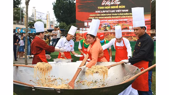 Les cuisiniers ont mis les ingrédients dans une grande casserole de 2m de diamètre pour cuisiner 1 000 plats de vermicelles sautés de style de Huê pour 1 000 personnes. Photo : Journal Thua Thiên Huê.