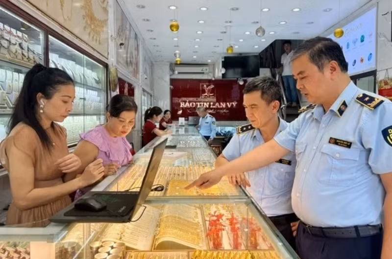 Inspecteurs du marché lors d'un contrôle de routine dans un magasin d'or de l'arrondissement de Cầu Giấy, Hà Nội. Photo : VNA. 