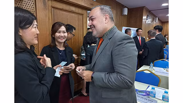 Les entreprises d'IDE échangent les investissements en marge de la conférence. Photo : baodautu.vn 