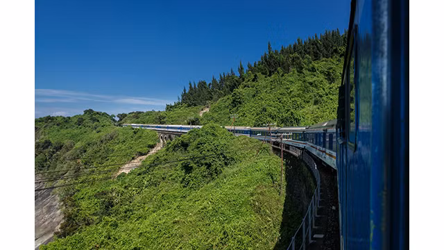 Les visiteurs peuvent profiter du paysage naturel et de la vie locale en train et acheter des collations auprès des vendeurs en cours de route. Photo : Vietnamnet.vn