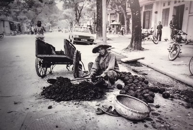 L'auteur photographiant un homme fabriquant du charbon de bois dans la rue en 1992. Photo: Andy Soloman. Photo : Andy Soloman.