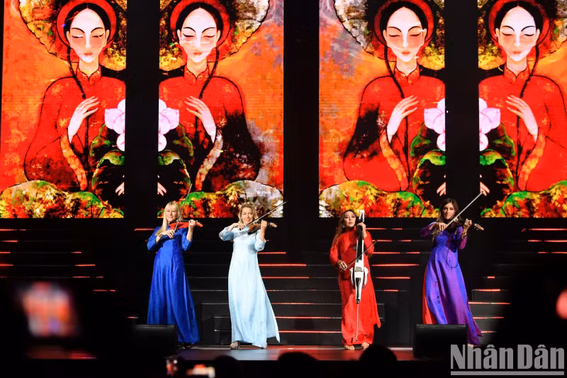 Le quatuor à cordes Bond vêtues d’ao dài (tunique traditionnelle vietnamienne) sur scène. Photo : nhandan.vn