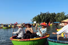 Des touristes internationaux découvrent le village de cocotiers de Cam Thanh, classé parmi les 50 plus beaux villages du monde en 2025. Photo : VNA. 