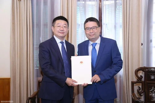 Le directeur du Département consulaire du ministère vietnamien des Affaires étrangères, Doan Hoang Minh, remet l’exequatur à Tang Li, nouveau consul général de Chine à Ho Chi Minh-Ville. Photo : Thanh Long/Baoquocte.